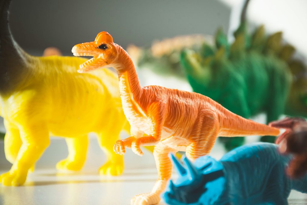 Plastic dinosaur figures at a dinosaur birthday party fossil dig activity