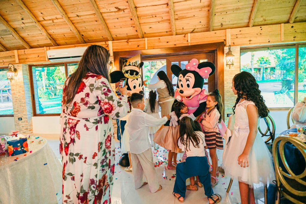A children's party entertainer performing magic tricks for excited kids at a birthday party